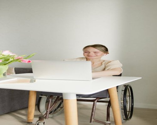 Person working on laptop in a well lit room with plants